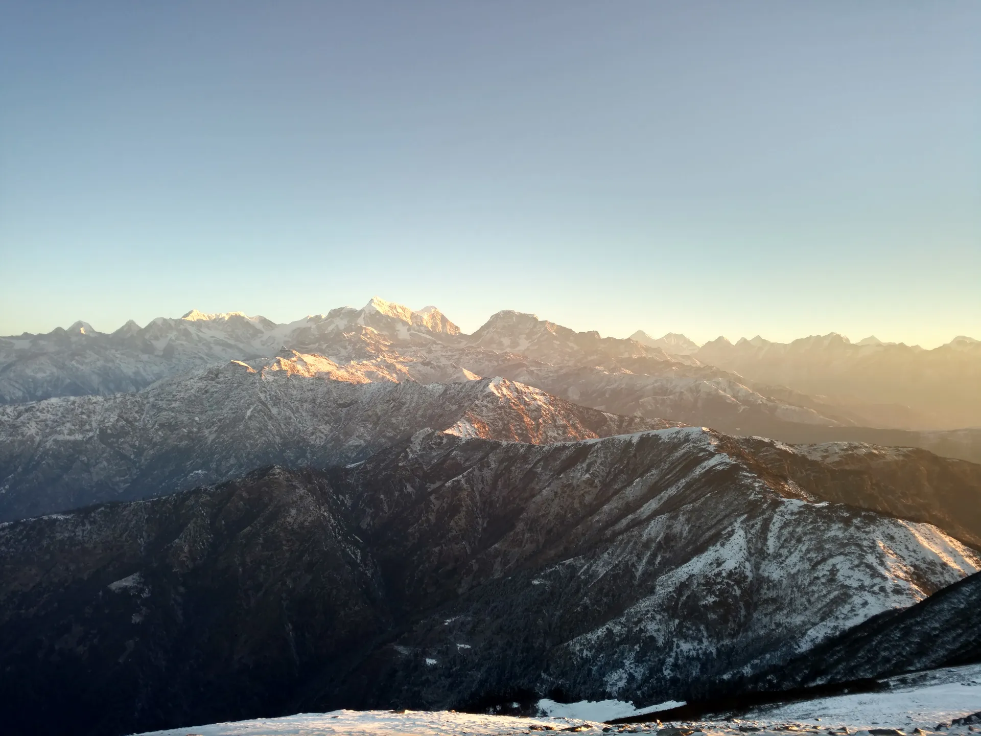 First light on a range of snow-covered Himalayan peaks.