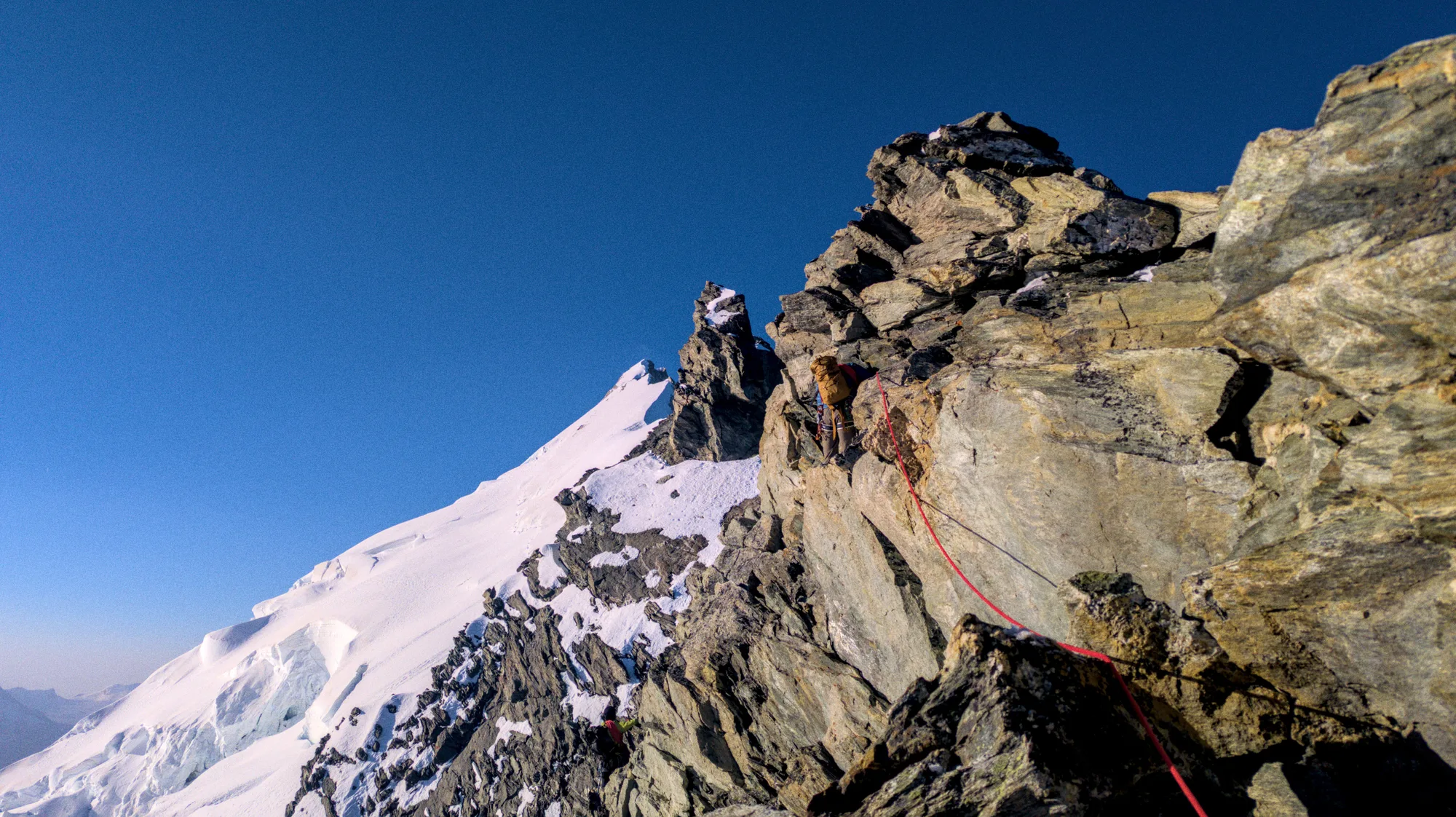 Exiting the rock climbing section of the Weisshorn north-ridge with view of the snow and ice section and summit