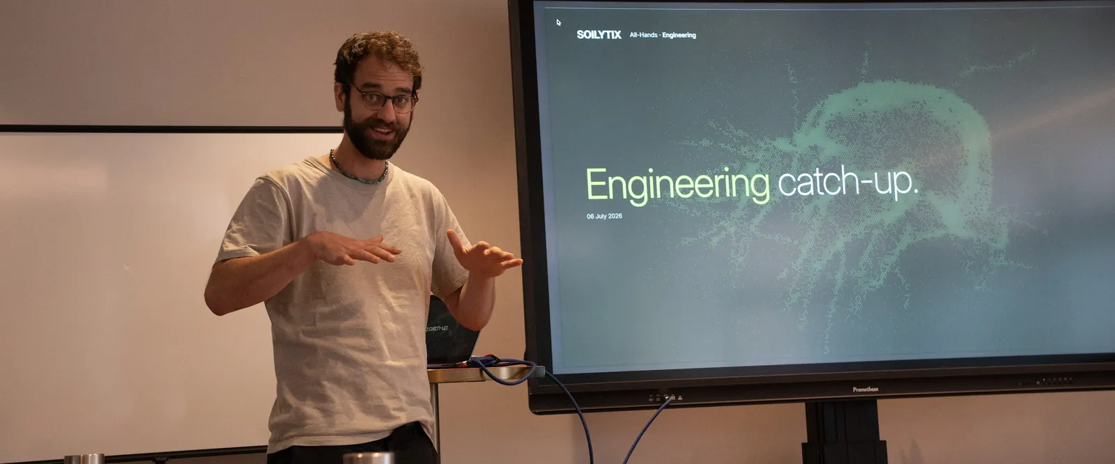Maurice presenting the Soilytix engineering catch-up at the July 2026 all-hands in Hamburg, gesturing beside a screen reading “Engineering catch-up.”